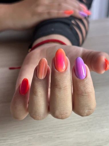 Degradado en rojo, naranja y lila sobre uñas almendradas — diseño multicolor verano