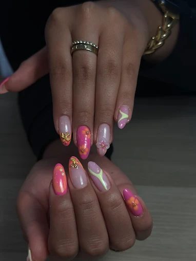 Uñas almendradas en rosa, coral y verde neón con detalles de flores — diseño veraniego de Arte y Miradas Oviedo